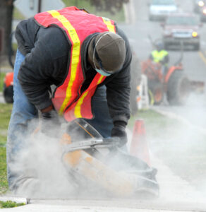 A construction worker cuts concrete.